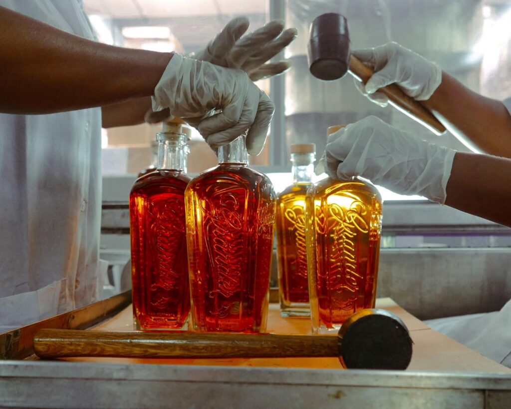 Placing cork tops onto Grander bottles